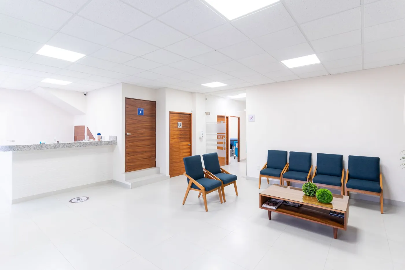 Clinic waiting area with chairs and wood doors