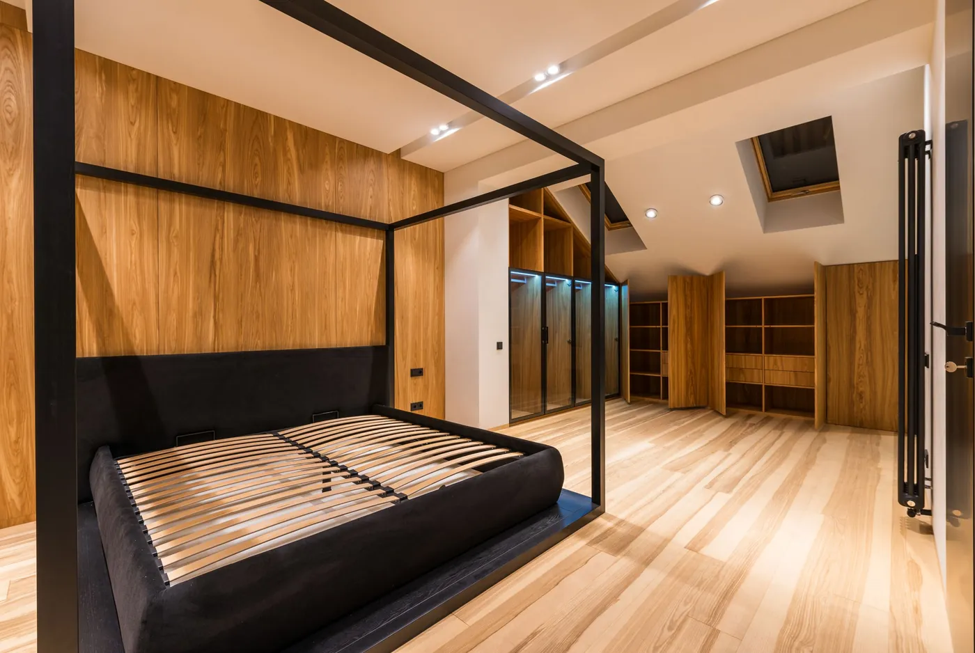 Bedroom with a four poster wood bed and wood panelled walls