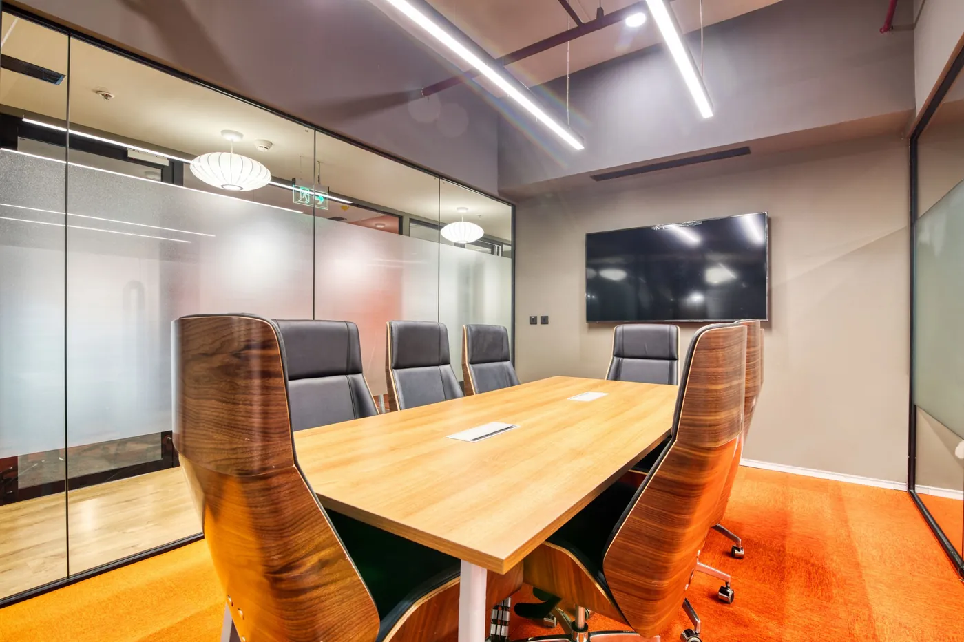 Meeting room with a wood table and orange leather chairs