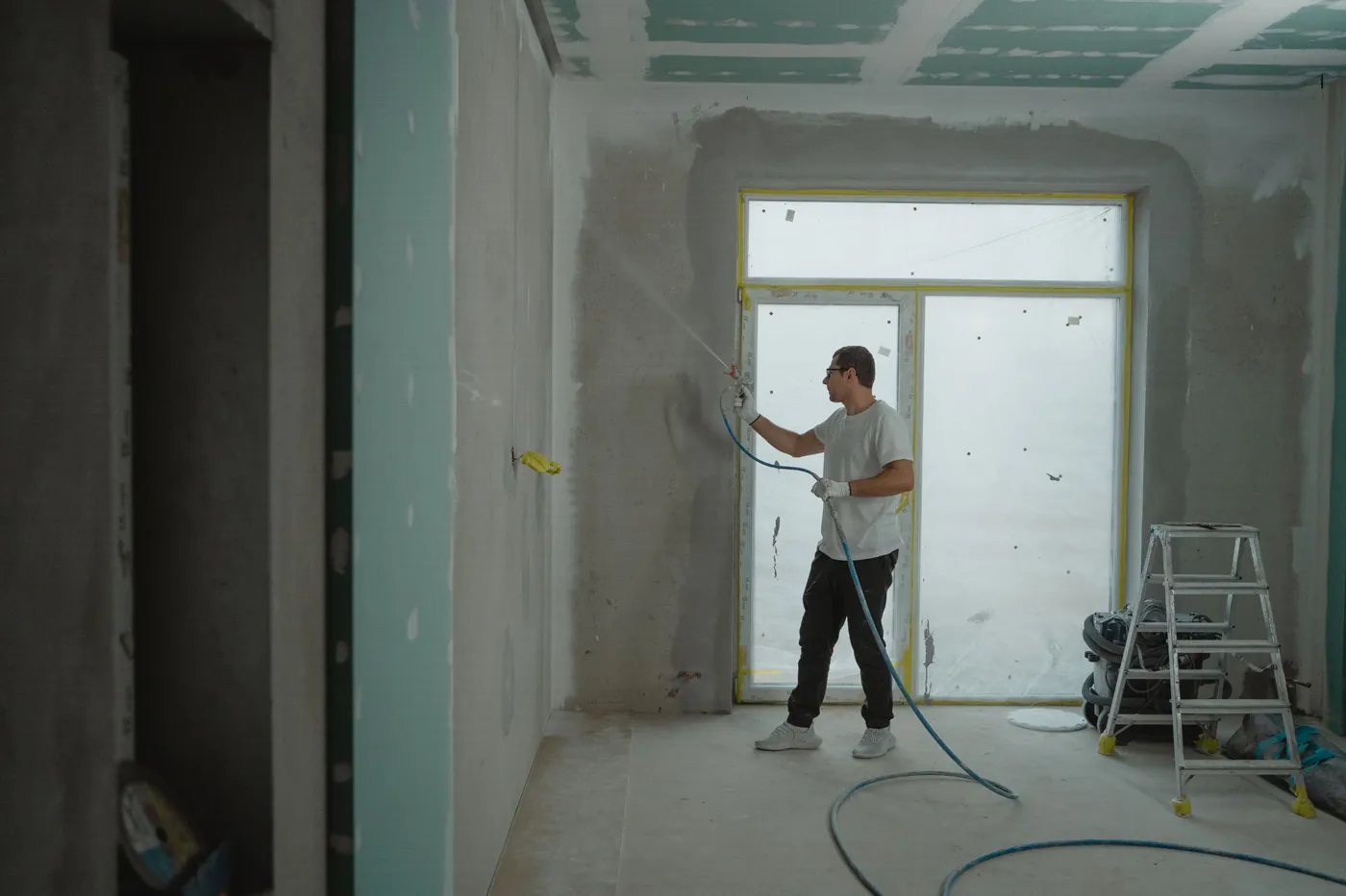 Worker finishing the walls of a room under renovation